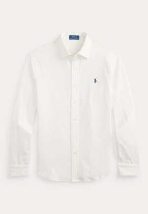Chemise blanche à manches longues, boutonnée avec col, avec petit logo Polo Ralph Lauren bleu marine brodé sur la poitrine gauche.