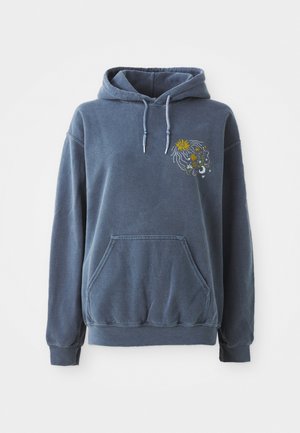 Modrá mikina s kapucňou, klokanie vrecko a rebrované manžety. Má farebnú kvetinovú výšivku na ľavej hrudi. Mäkko, textúrované tkanivo.