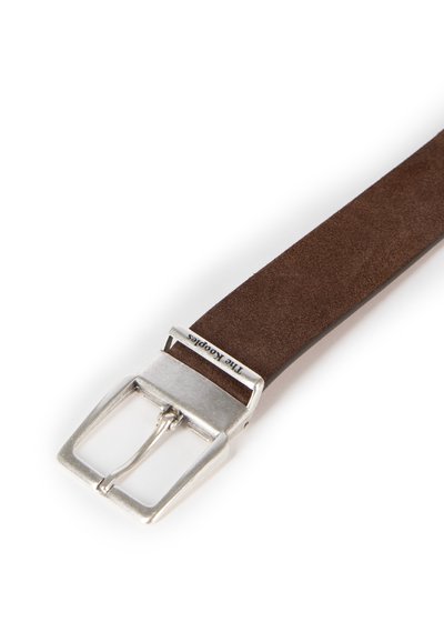 Brązowy zamszowy pasek z prostokątną srebrną metalową sprzączką, o gładkiej fakturze i grawerunku z logo na sprzączce.