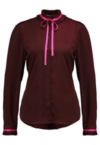 Blusa bordeaux a maniche lunghe con colletto arricciato, fiocco rosa e dettagli rosa sui polsini. Tessuto morbido e chiusura con bottoni.
