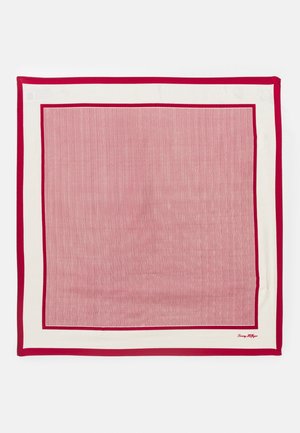 Écharpe en soie rayée rouge et blanche avec une bordure rouge unie contrastante et un petit logo dans le coin. Surface texturée avec des détails fins.