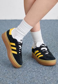 Niet geselecteerd, core black/bold gold/footwear white