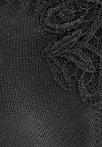 Tejido negro con una textura suave, que presenta intrincados bordados negros en un patrón floral, creando profundidad e interés visual.