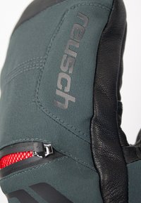 Grüne und schwarze Fäustlinge aus strukturiertem Stoff und Leder, mit einer Reißverschlusstasche und rotem Netzfutter sowie bedrucktem Branding.
