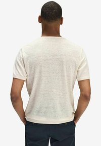 Kortærmet cremet t-shirt med et struktureret, let stof, der har en klassisk rund halsudskæring og en lige bundkant.
