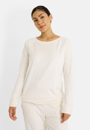 Top de manga larga color crema con patrón de leopardo texturizado, escote redondeado y corte relajado. Tejido suave con ligero elastano.