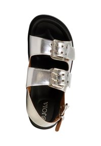Sandale argentée avec deux brides réglables à boucle et semelle intérieure noire contournée, vue de dessus sur fond blanc.