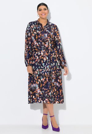 Robe à manches longues en tissu soyeux présentant un motif abstrait multicolore avec des tons orange, vert et marine ; inclut une ceinture et un col.