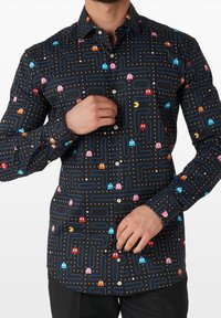 Zwarte overhemd met knopen, voorzien van een Pac-Man ontwerp met kleurrijke spoken, een labyrintachtig patroon en witte stippen. Lange mouwen met knoopmanchetten.