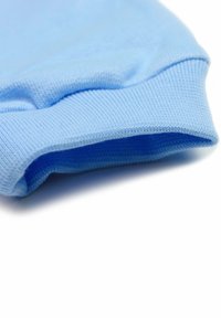 Lichtblauw gebreide stof met een ribbelsmanchet. De textuur lijkt glad en zacht, met een licht rekbaar gevoel.