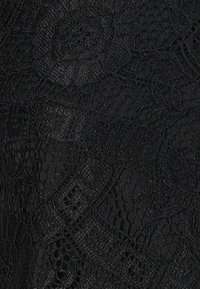 Svart spetstyg med intrikata blommönster och texturerade ytor, med varierande trådtyck och detaljer i öppen väv.