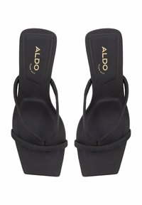 Black platform sandals with a textured strap design, featuring a matte finish and gold branding on the upper surface.