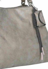Sac à main en simili cuir gris avec une texture lisse, un éclat subtil, un charme amovible et un détail de bandoulière tressé. Logo embossé sur la surface.