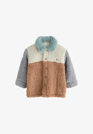 Faux fur jakke med en tan farvet krop, kridhvid, grå og mintfarvet krave. Knaplukning og et mærke med et dyremotiv på brystet.