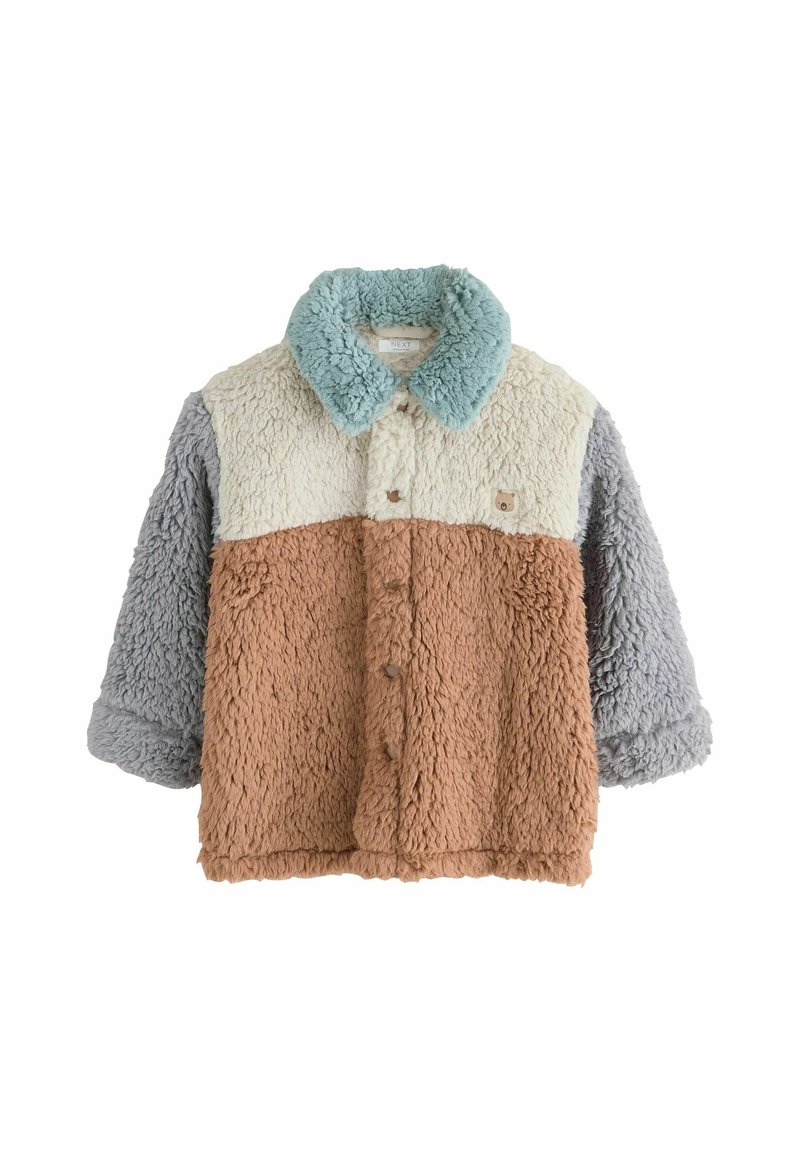 Veste en fausse fourrure avec un corps beige, un col crème, gris et menthe. Fermeture à bouton et un patch avec un motif animal sur la poitrine.