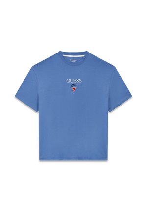 Sinine puuvillane T-särk, millel on ümmargune kaelus, lühikesed varrukad ja tikitud "GUESS" logo punase kolmnurkse detailiga rinnal.