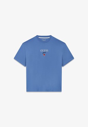 Sinine puuvillane T-särk, millel on ümmargune kaelus, lühikesed varrukad ja tikitud "GUESS" logo punase kolmnurkse detailiga rinnal.