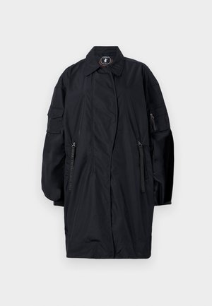 Dlouhý černý oversized kabát s širokými rukávy, předními kapsami na zip, límcem a štítkem bez zvířat uvnitř límce.