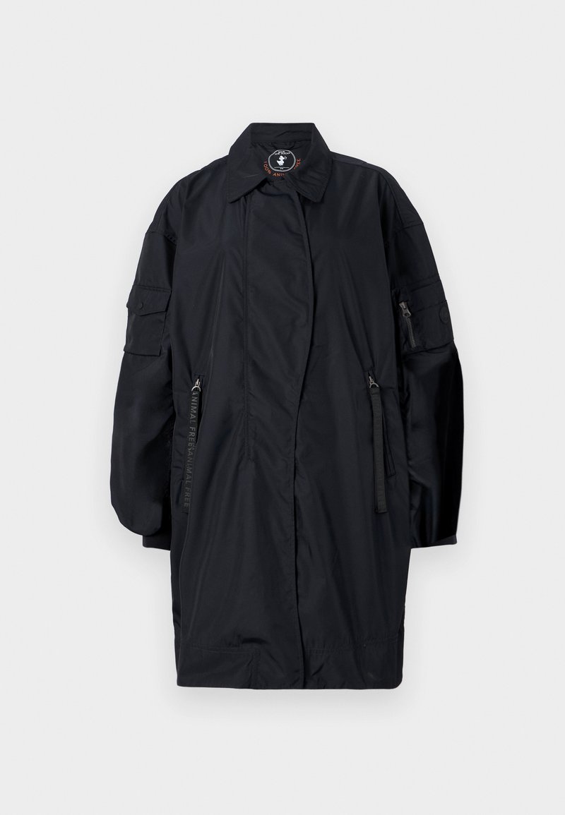 Abrigo largo negro de gran tamaño con mangas anchas, bolsillos frontales con cremallera, cuello y una etiqueta libre de animales dentro del cuello.