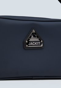 Borsa navy con finitura testurizzata, caratterizzata da una patch a logo nero triangolare con accenti in argento. Superficie liscia e materiale resistente.
