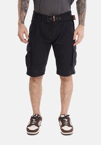 Pantaloni cargo neri realizzati in tessuto, dotati di più tasche laterali, una cintura con un accento marrone e un taglio fino al ginocchio.