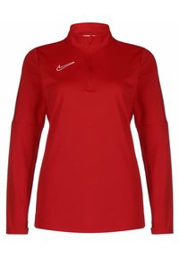 Červený pulovr s dlouhým rukávem a zipem ve čtvrtinovém stylu. Na levé straně je bílé logo Nike. Vyrobeno z hladkého, elastického materiálu.