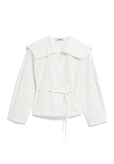 Biała, długorękawowa bluzka zapinana na zakładkę z dużym kołnierzem i cienkim paskiem w talii, wykonana z lekkiego materiału, ułożona płasko na białym tle.