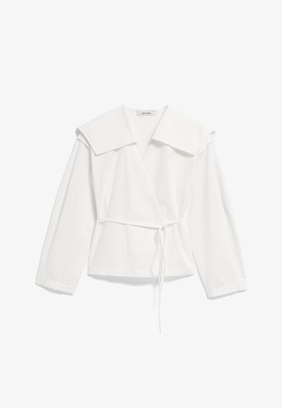 Biała, długorękawowa bluzka zapinana na zakładkę z dużym kołnierzem i cienkim paskiem w talii, wykonana z lekkiego materiału, ułożona płasko na białym tle.