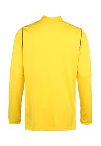 Langärmliges gelbes Sporthemd mit strukturierten Oberflächen, ausgestattet mit schwarzer Paspelierung entlang der Schulternähte und einem hohen Kragen.