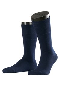Calzini in cotone blu navy con una texture liscia, design aderente e branding discreto. Presentano una lunghezza alla caviglia e un'area della punta rinforzata.