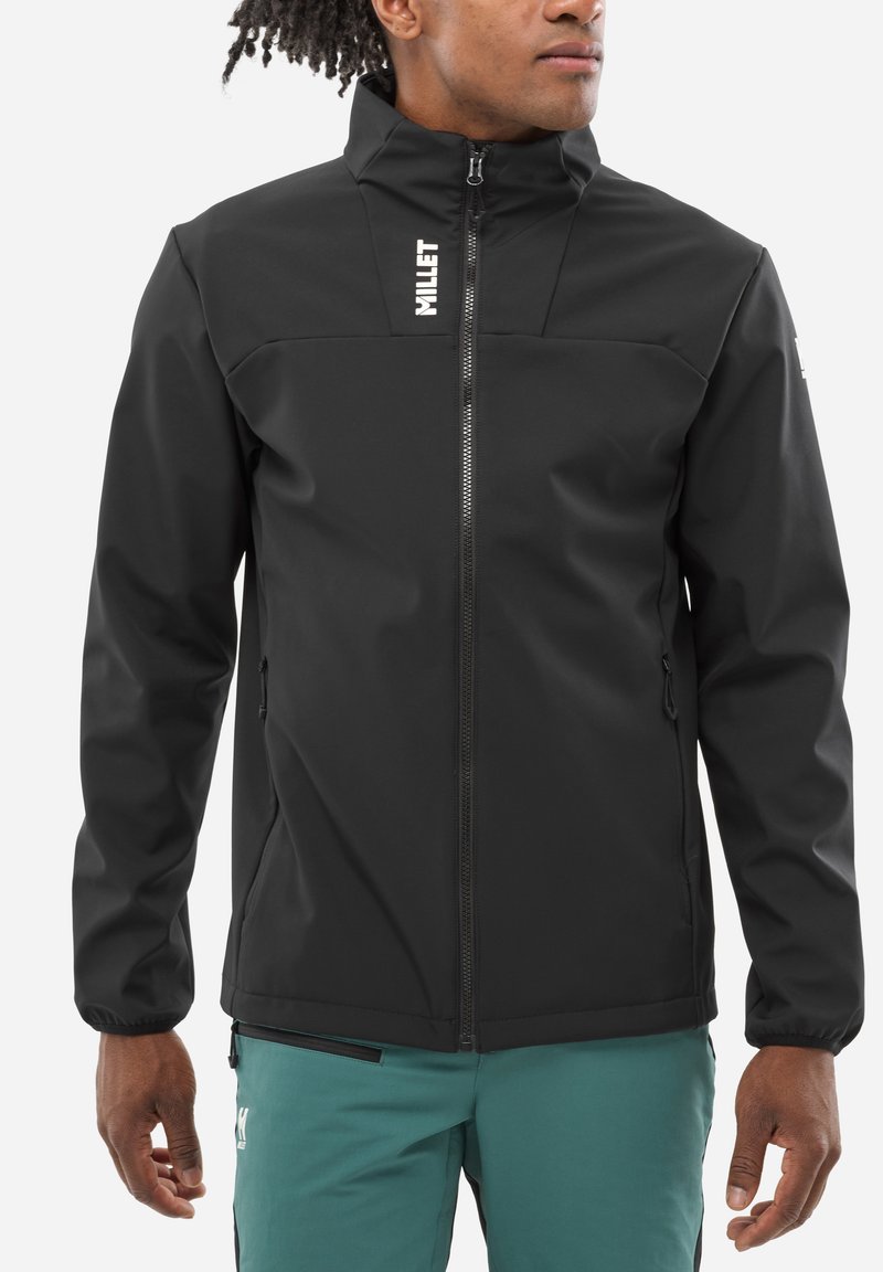 Veste softshell noire avec col haut, devant zippé et logo sur la poitrine. Dispose de manchettes élastiques et de deux poches latérales.