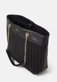 Bolso tote negro hecho de cuero sintético trenzado, con una textura trenzada, correas de cadena en tono dorado y cierre a presión.