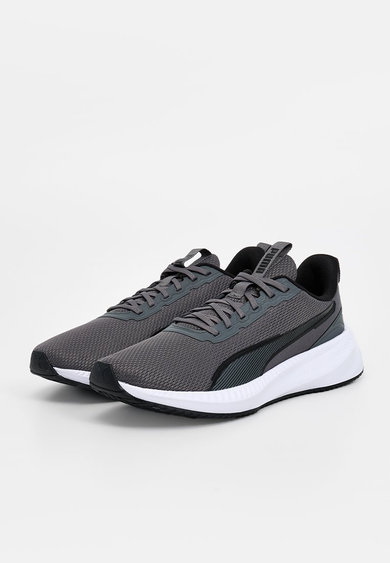 Zapatillas deportivas grises con parte superior de malla, detalles en negro, cuello acolchado y una entresuela blanca; diseñadas para la comodidad y el rendimiento.