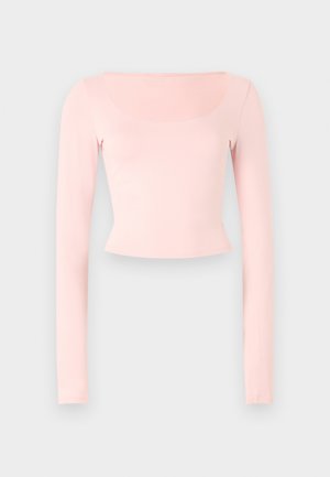 Crop top rose à manches longues avec un col carré, fabriqué en tissu doux, présentant un design ajusté et une texture lisse.