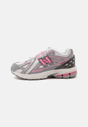 Chaussure de course blanche et grise avec des accents roses, col rembourré et semelle amortissante, vue de côté sur fond blanc.