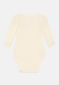 Bodysuit de bebé de manga larga en tela de canalé crema, con un cuello redondo y cierre a presión en la parte inferior para facilitar el vestuario.