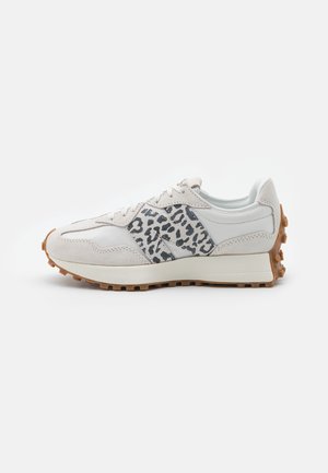 Witte en beige sneaker met luipaardprintaccent aan de zijkant en een getextureerde bruine rubberen zool met profiel voor grip.