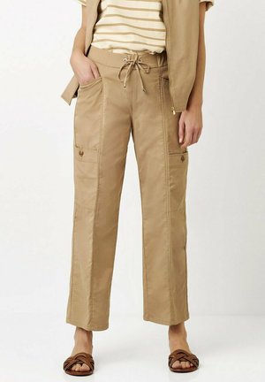 Beige Cargo-Hosen mit lockerer Passform, elastischem Zugbandbund, Seitentaschen und dezenten Nähdetails. Glattes, leichtes Material.