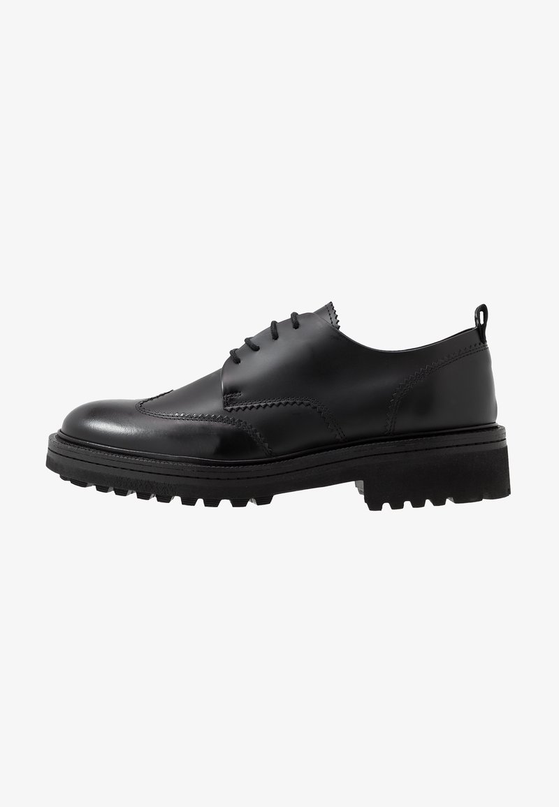 Chaussure habillée noire en cuir à lacets avec une semelle épaisse à crampons et des détails cousus, vue de côté.
