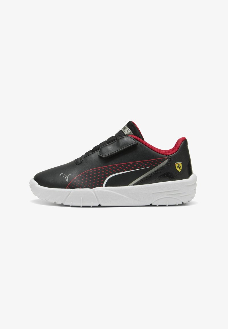 Zapatillas sintéticas negras con acentos rojos, que presentan un diseño texturizado, suela blanca, correa de velcro y pequeño logo de Ferrari en el talón.