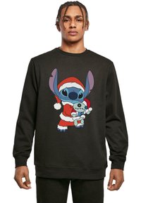 Felpa nera con una grafica colorata che rappresenta un personaggio in un costume di Babbo Natale rosso, che tiene un giocattolo, con dettagliata espressione facciale e accenti blu.