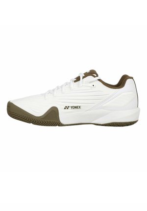 Witte Yonex sportschoen met bruine zool en binnenvoering, veterontwerp en getextureerde zijkant voor grip en ondersteuning.