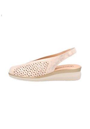 Zapato slingback beige claro con patrón geométrico recortado y suela baja en cuña, diseñado para comodidad y ventilación.
