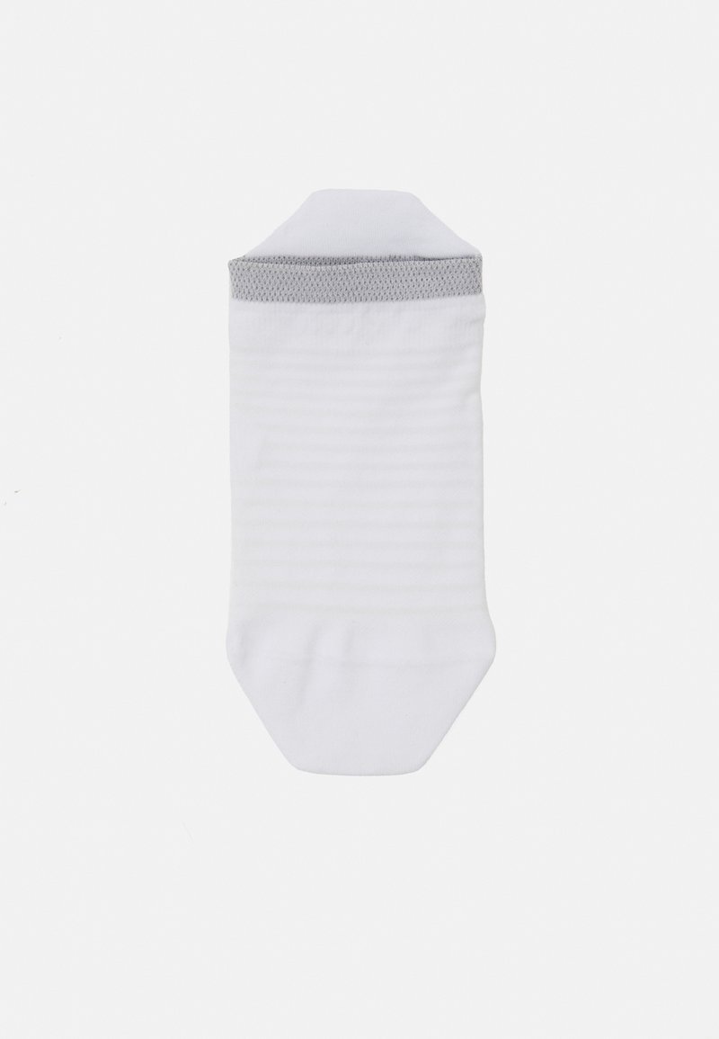 Calcetín blanco hasta el tobillo con un puño a rayas grises. Hecho de un tejido suave y texturizado con sutiles rayas horizontales. Diseño de punta redondeada.