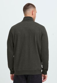 Dark gray sweatshirt with a high collar, long sleeves, and ribbed cuff and hem. Fabric appears soft with a smooth texture, minimal detailing.
