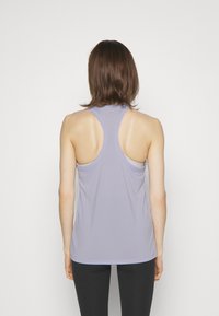 Canotta atletica senza maniche di colore viola chiaro con design racerback; realizzata in tessuto traspirante, morbido al tatto e con orlo arrotondato.