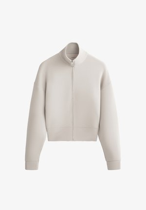 Zkrácená, světle béžová mikina na zip s vysokým límcem, spadlými rameny a žebrovanými manžetami, vyrobená z měkké, texturované látky.
