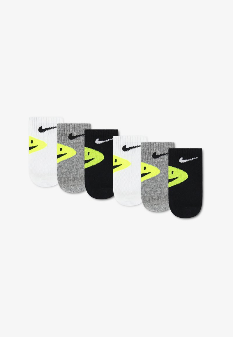 Six paires de chaussettes de sport, comprenant les couleurs blanc, gris et noir, chacune ornée d'un logo Nike jaune et noir.