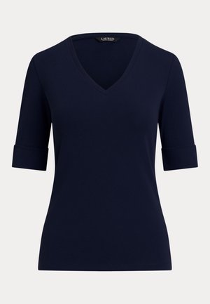 T-shirt femme bleu marine à manches courtes avec col en V, poignets repliés et silhouette ajustée.