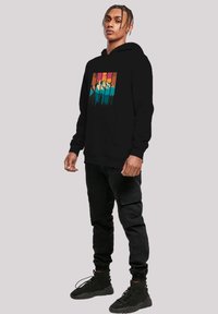 Black hoodie featuring a colorful mountain and forest graphic on the front. Made of soft fabric with a relaxed fit and kangaroo pocket.
